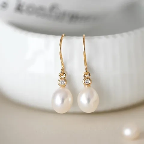 Ovaal 7 - 8 mm aaa-graded zoetwaterparel briljant oorbellen in 14 karaat goud met diamanten 