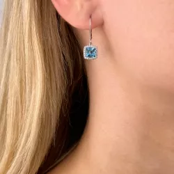 lange blauwe topaas oorbellen in 14 karaat witgoud met diamant en topaas 